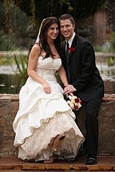 Bride and groom posing by the water.