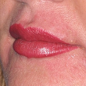 Close-up of lips with red lipstick.