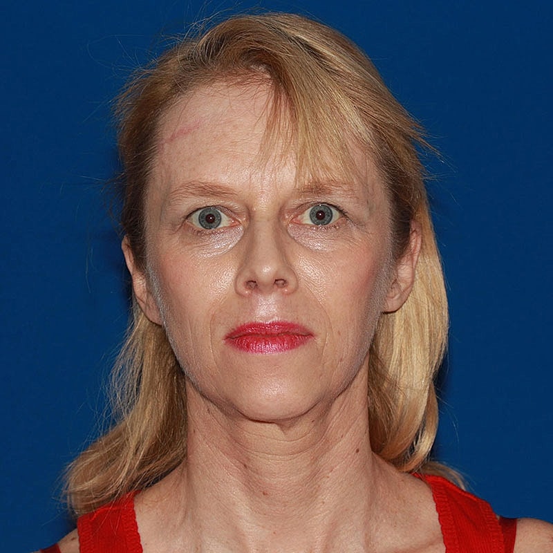 Woman with blonde hair against blue background.