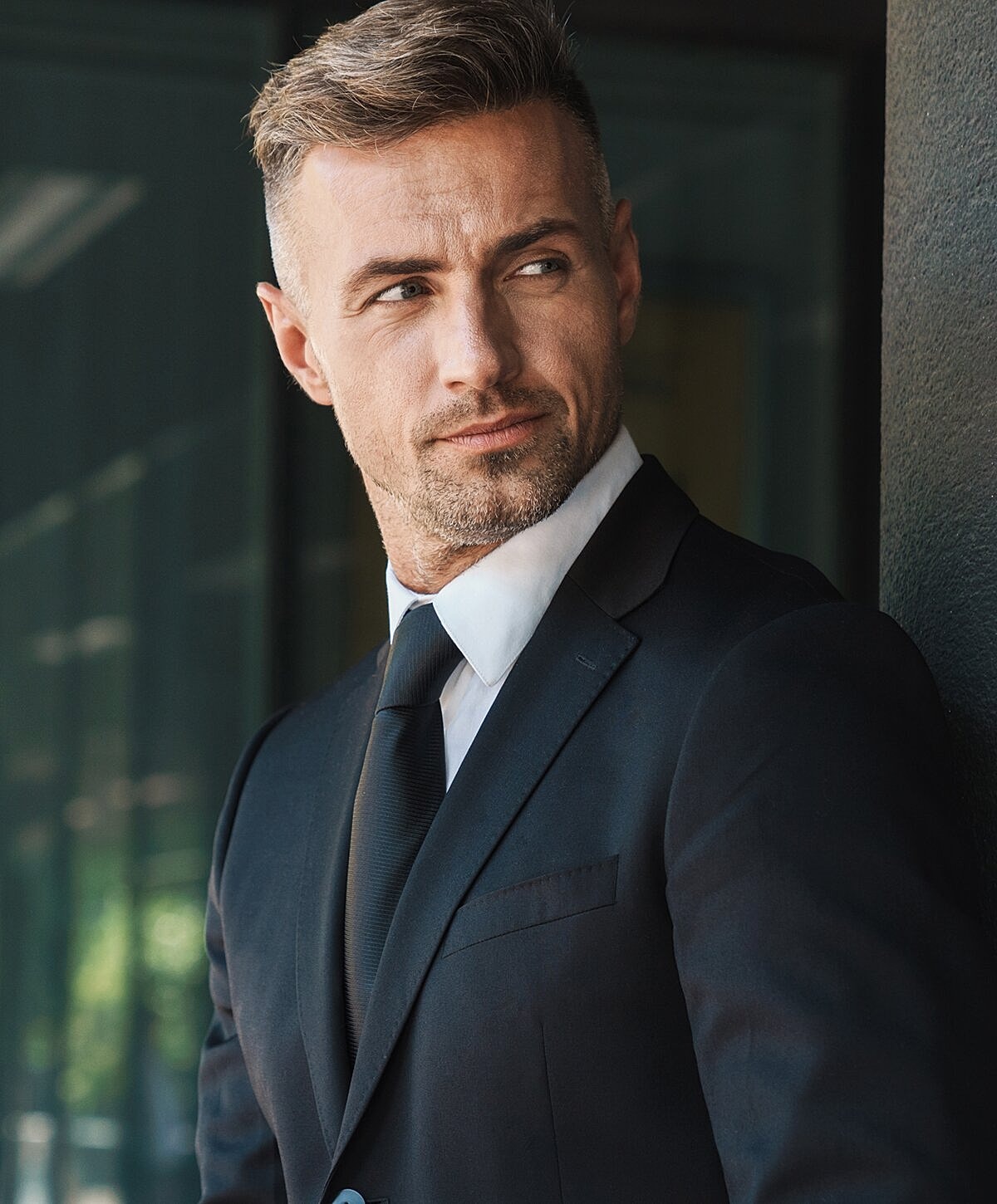 Man in a suit looking confidently sideways.