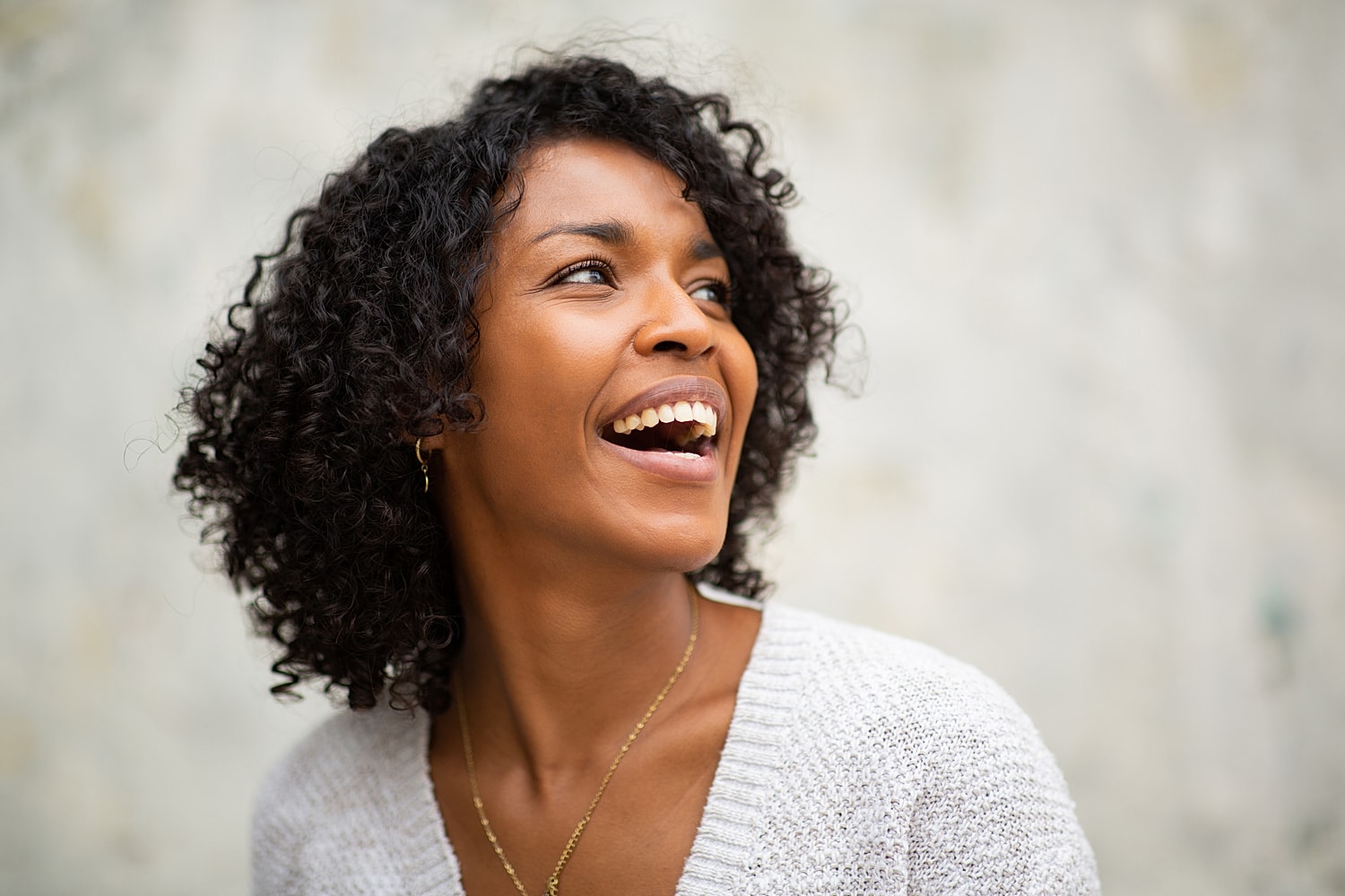 Smiling woman with curly hair, enjoying life.