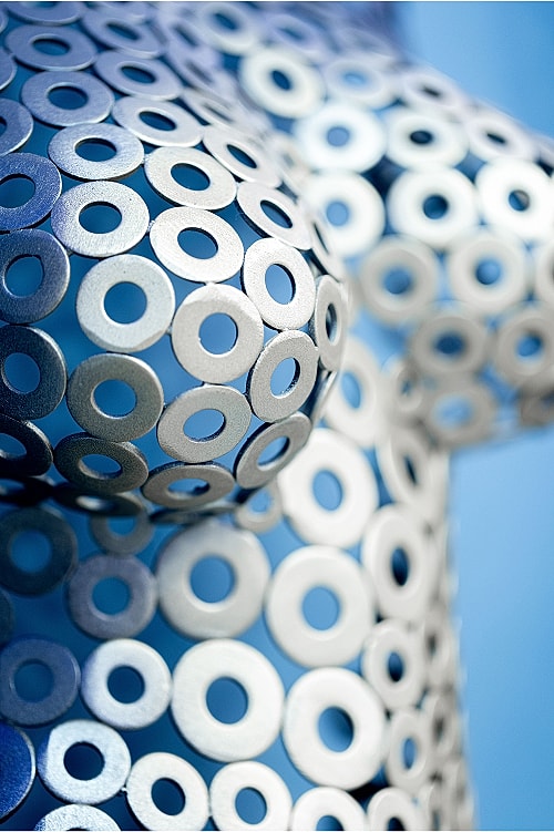 Metallic sculpture covered in circular cutouts.