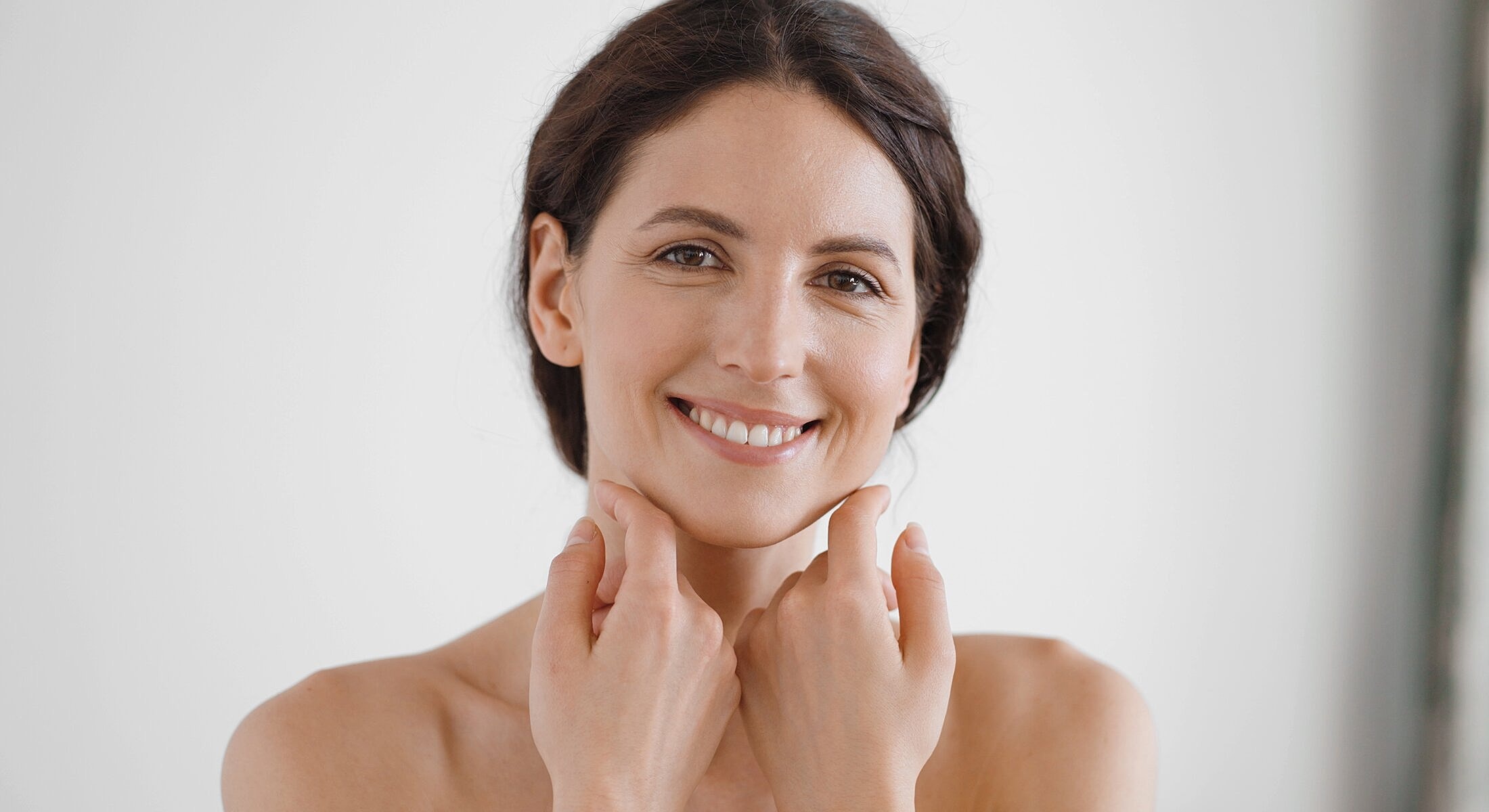 Smiling woman touching her face gently