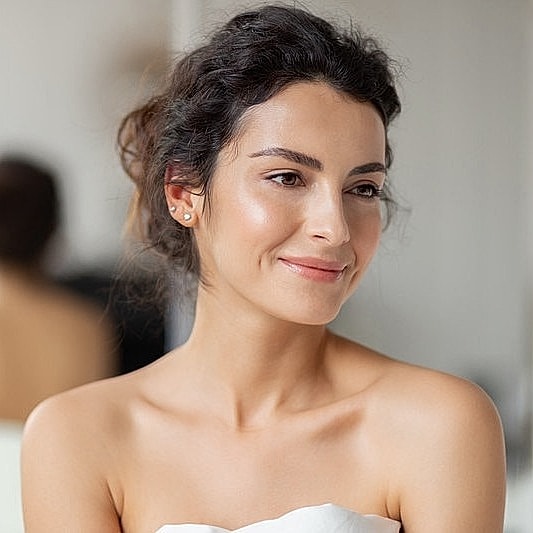 Smiling woman in black dress holding tablet.